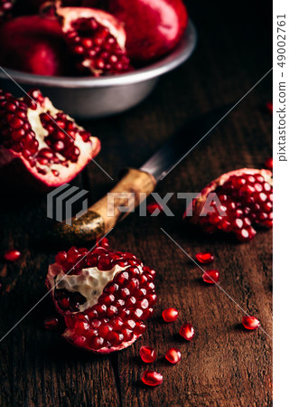 Pomegranate pieces on rustic wooden surface Pomegranate pieces on rustic wooden surface 49002761