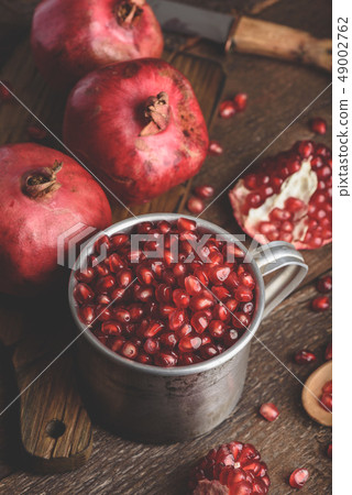 Rustic metal mug full of pomegranate seeds Rustic metal mug full of pomegranate seeds 49002762