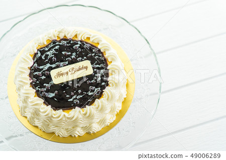 Blueberry cheese cake with happy birthday sign on top Blueberry cheese cake with happy birthday sign on top 49006289