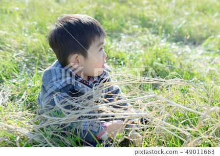 Side view of 3 years old child playing outside Side view of 3 years old child playing outside 49011663