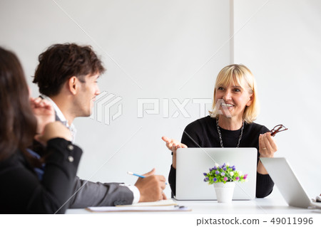 Smiling aged business woman talking and looking 49011996