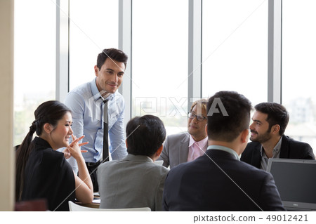 Chief businessman standing at conference table 49012421