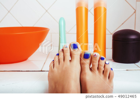 woman legs in bathroom with lot of stylish stuff for care, pedicure creative design, hygiene spa woman legs in bathroom with lot of stylish stuff for care, pedicure creative design, hygiene spa 49012465