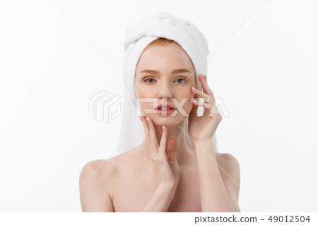 beautiful model applying cosmetic cream treatment on her face on white. beautiful model applying cosmetic cream treatment on her face on white. 49012504