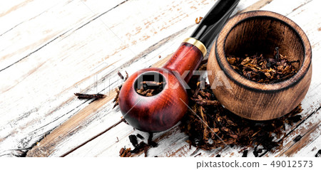 Smoking pipe on a wooden table Smoking pipe on a wooden table 49012573
