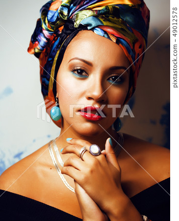 beauty bright african woman with creative make up, shawl on head like cubian closeup smiling 49012578