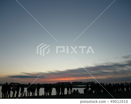 Spectators at sunrise with blue sky and clouds Spectators at sunrise with blue sky and clouds 49012818