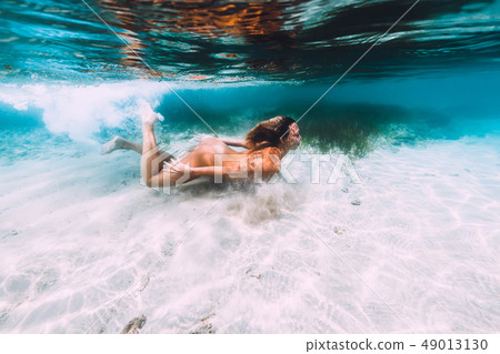 Attractive naked woman swimming in tropical sea Attractive naked woman swimming in tropical sea 49013130