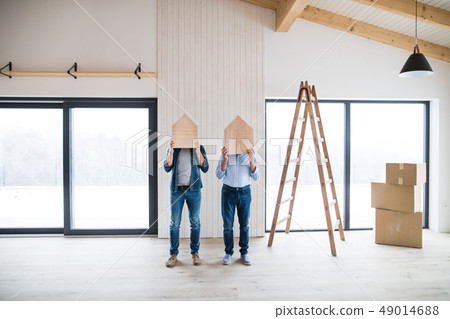 Men holding wooden houses on their heads when furnishing new house, a concept. 49014688