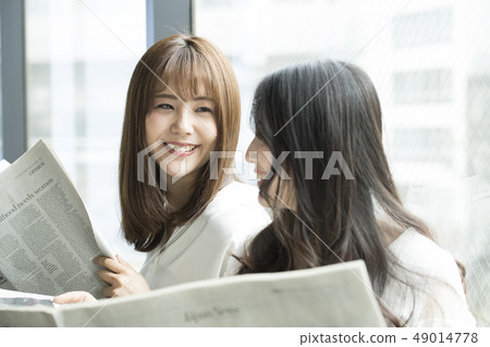 讀報紙的兩名婦女在窗口邊 49014778