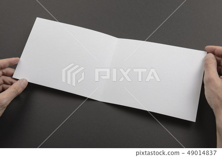 Mens hands holding white booklet Mens hands holding white booklet 49014837
