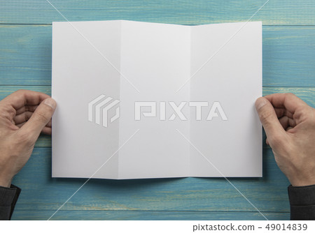 Mens hands holding white booklet Mens hands holding white booklet 49014839
