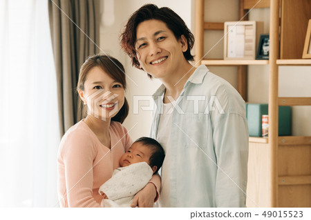 抱著嬰孩育兒房子的年輕夫婦 抱著嬰孩育兒房子的年輕夫婦 49015523