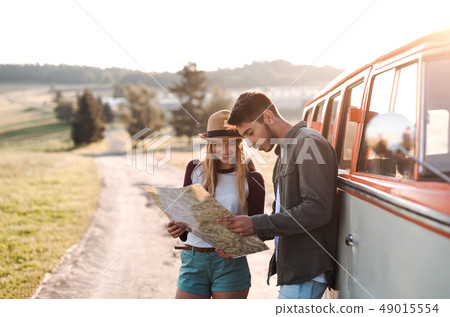 A young couple on a roadtrip through countryside, looking at a map. A young couple on a roadtrip through countryside, looking at a map. 49015554