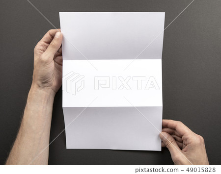 Mens hands holding white booklet Mens hands holding white booklet 49015828