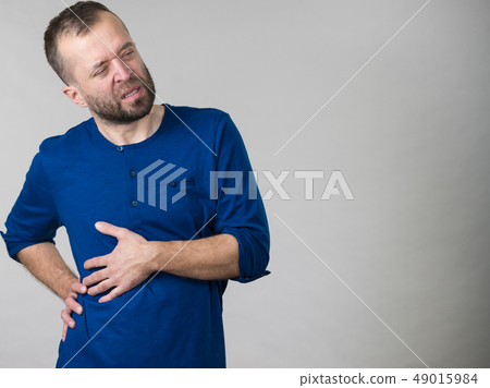 Man having stomach or ribs pain ache. Man having stomach or ribs pain ache. 49015984