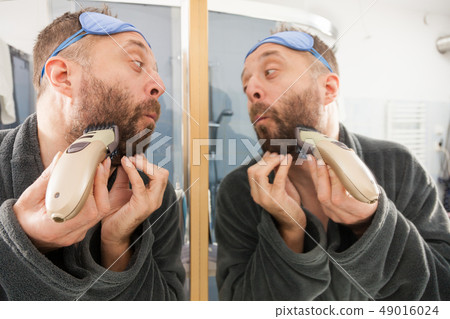 Man shaving trimming his beard 49016024