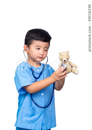 Smiling Asian kid in blue medical uniform holding Smiling Asian kid in blue medical uniform holding 49016296