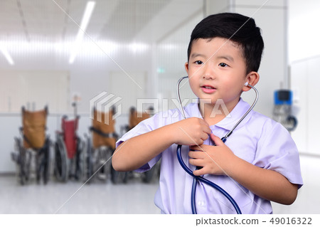 Asian Thai kid with medical stethoscope looking at Asian Thai kid with medical stethoscope looking at 49016322