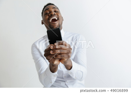 Indoor portrait of attractive young black african man isolated on pink background, holding blank 49016899