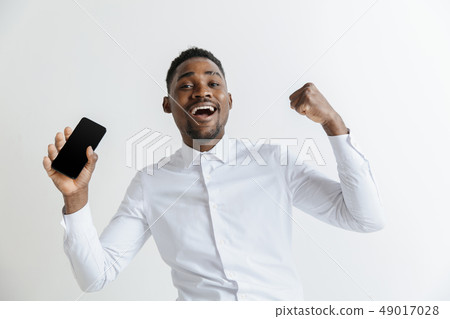 Indoor portrait of attractive young black african man isolated on pink background, holding blank Indoor portrait of attractive young black african man isolated on pink background, holding blank 49017028