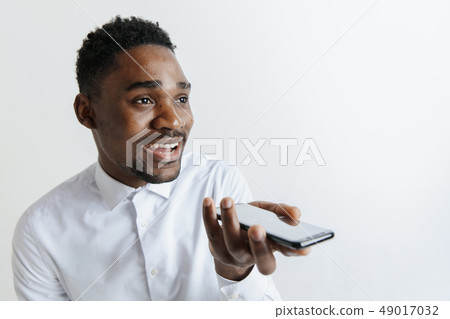 Indoor portrait of attractive young black african man isolated on gray background, holding blank Indoor portrait of attractive young black african man isolated on gray background, holding blank 49017032