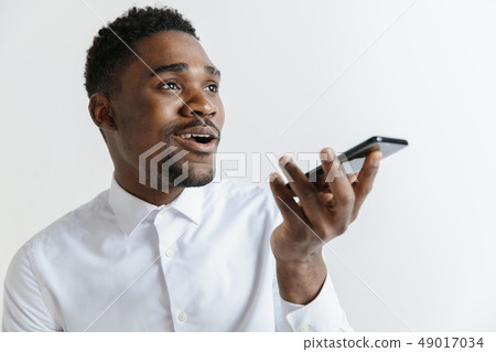 Indoor portrait of attractive young black african man isolated on gray background, holding blank Indoor portrait of attractive young black african man isolated on gray background, holding blank 49017034