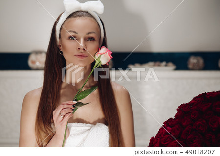 Attractive sensual woman with rose bud smiling at 49018207