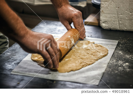 Male hands roll out shortbread gingerbread dough. 49018961