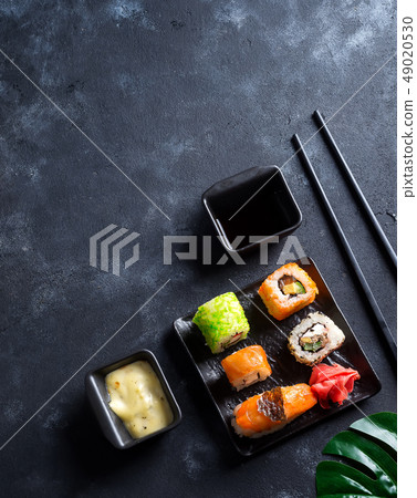 Various Fresh and delicious sushi set on black slate with slate sticks, sauce and nori on black 49020530