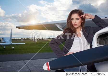 Businesswoman standing by his private plane 49020597