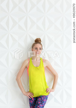 Sporty young woman standing over white wall 49020970