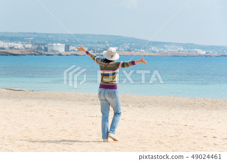 Happy woman in hat on the beach. Summer holidays, vacation, travel and people concept 49024461
