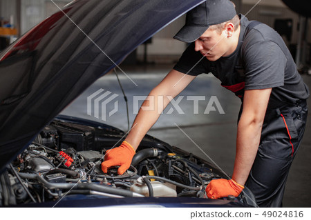 Mechanic is changind an oil. Mechanic is changind an oil. 49024816