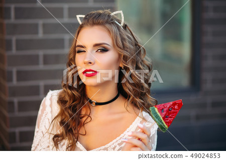 Pretty charming girl like cat with candy in hand. Pretty charming girl like cat with candy in hand. 49024853