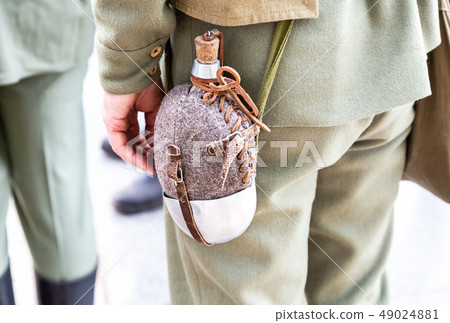 Vintage military flask hangs on a belt from a 49024881
