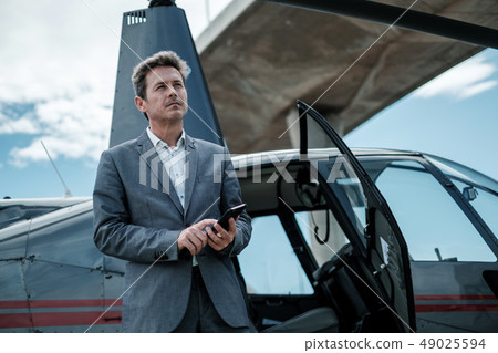 Businessman standing near private helicopter Businessman standing near private helicopter 49025594