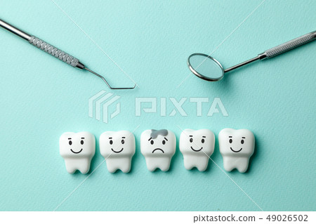 Healthy white teeth are smiling and tooth with caries is sad on green mint background and dentist Healthy white teeth are smiling and tooth with caries is sad on green mint background and dentist 49026502