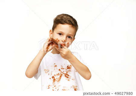 little messy boy is eating chocolate studio shot little messy boy is eating chocolate studio shot 49027980