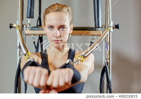 gym woman pilates stretching sport in reformer bed instructor girl. Selective focus on hands gym woman pilates stretching sport in reformer bed instructor girl. Selective focus on hands 49028955