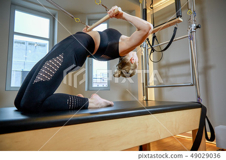 gym woman pilates stretching sport in reformer bed instructor girl. Healthy Smiling Woman Wearing gym woman pilates stretching sport in reformer bed instructor girl. Healthy Smiling Woman Wearing 49029036