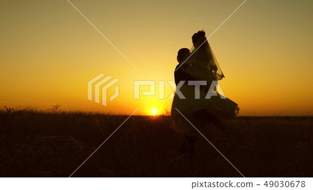 Young bride and groom circling on background of romantic red sunset. Honeymoon. The relationship 49030678