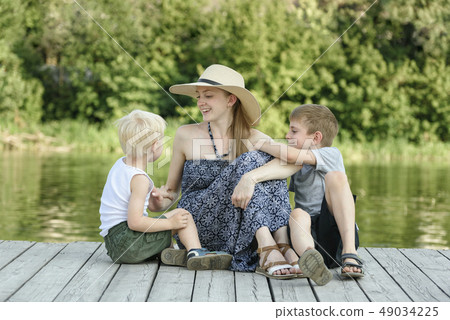 Beautiful mother with two young sons are sitting 49034225