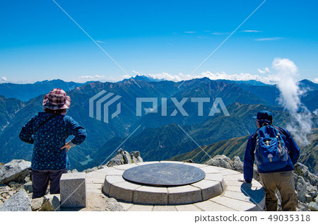A mountain climber who looks at the top of the mountain at the top of Mt. A mountain climber who looks at the top of the mountain at the top of Mt. 49035318