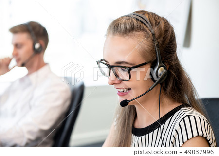 Friendly woman working in call center office Friendly woman working in call center office 49037996
