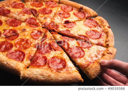 Taking slice of pepperoni pizza 49039366
