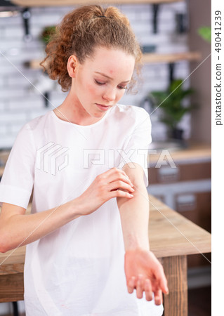 Disturb long-haired girl in white t-shirt covered in red spots Disturb long-haired girl in white t-shirt covered in red spots 49041239