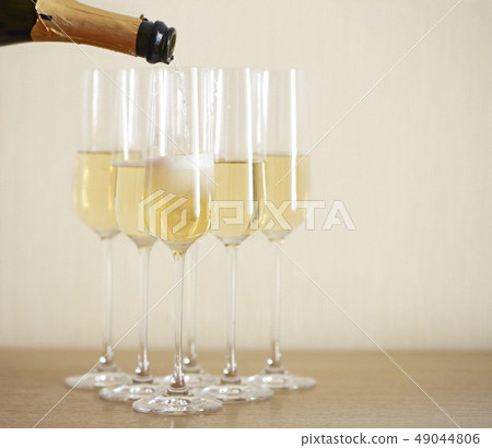 Pouring champagne from bottle into six transparent Pouring champagne from bottle into six transparent 49044806