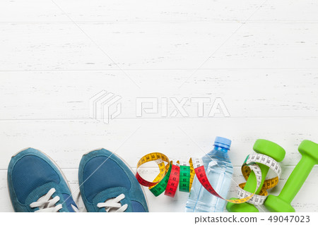 Fitness concept. Dumbbells, sneakers and tape Fitness concept. Dumbbells, sneakers and tape 49047023