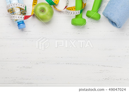 Fitness concept. Dumbbells, tape measure and apple 49047024